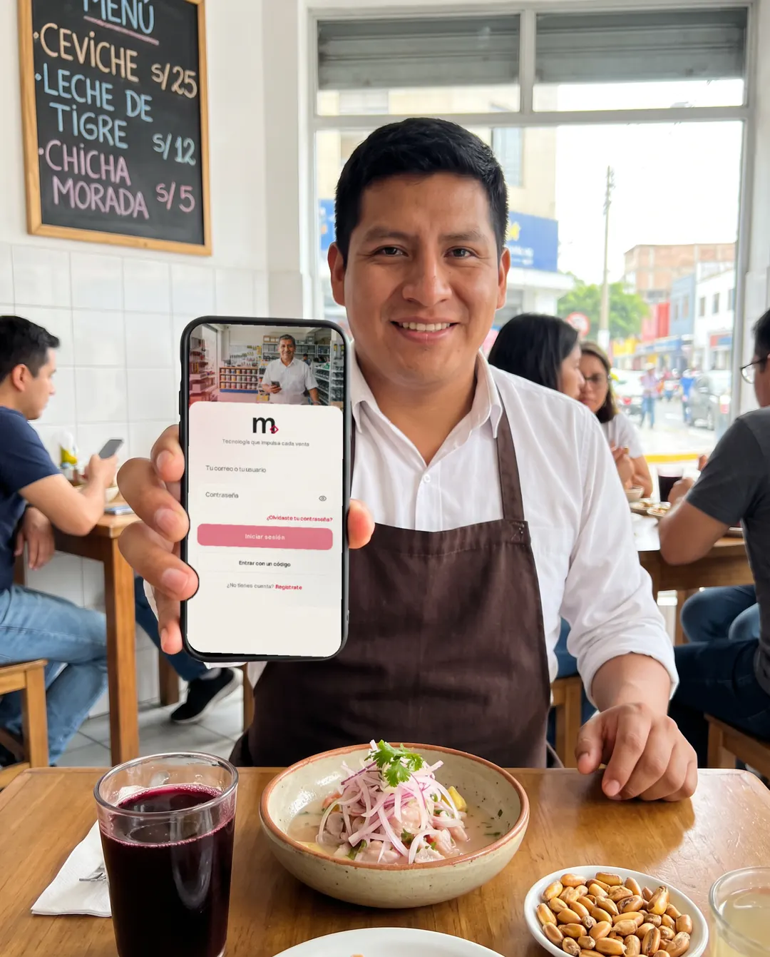 Mozo de una cevichería muestra Musuq en su celular junto a la mesa.